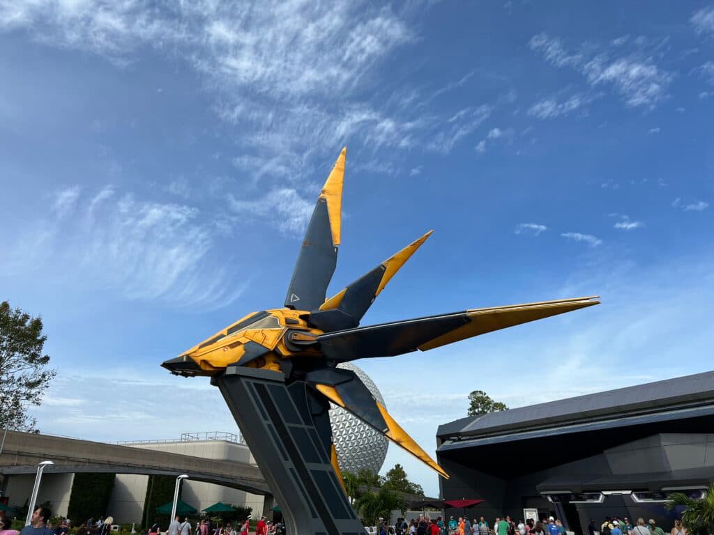 Nave dos Guardiões da Galáxia na entrada da nova atração Guardians of the Galaxy Cosmic Rewind do parque temático Epcot na Disney World. É possível ver pessoas, o céu azul e uma parte da Spaceship Earth ao fundo
