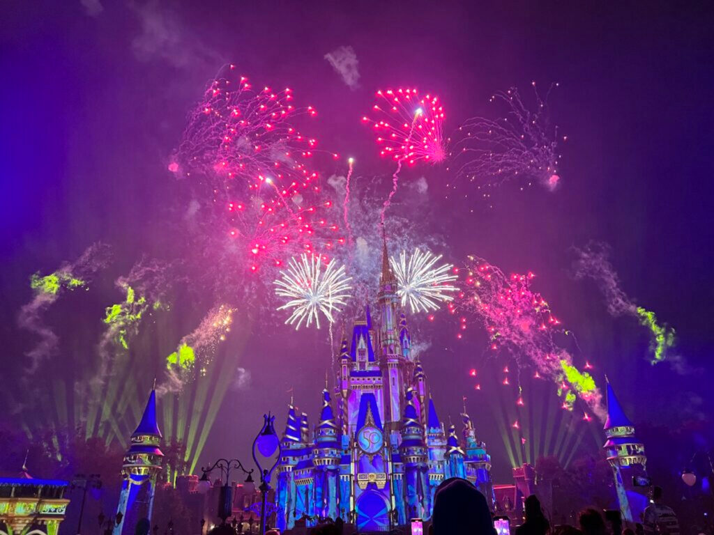 Castelo da Cinderela no parque Magic Kingdom da Walt Disney World Resort em Orlando, na Flórida, com luzes e fogos de artifício coloridos no céu.