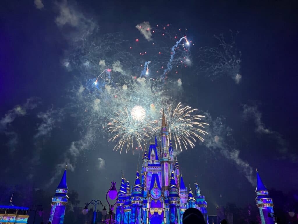 Foto do Castelo da Cinderela no parque Magic Kingdom em Walt Disney World Resort Florida, iluminado a noite durante o show de fogos de artifício de encerramento a noite