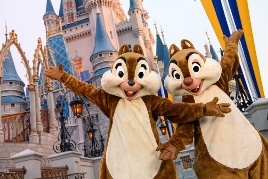 Os personagens Tico e Teco posam felizes e de braços abertos em frente ao castelo da Cinderela no parque de diversões Magic Kingdom em Walt Disney World Resort Orlando