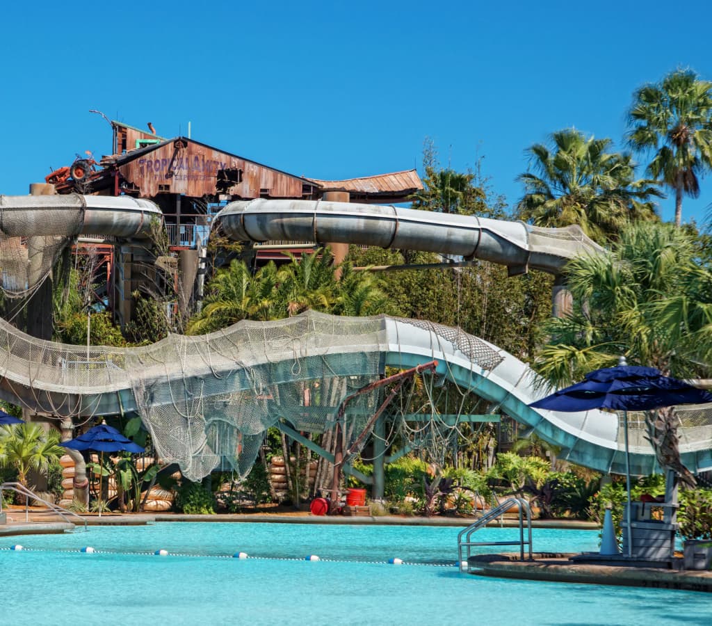 Foto de um dos toboáguas principais do parque aquático Typhoon Lagoon da Disney, mostra um galpão em ruínas destruído pelo tufão, de onde saem dois tobogãs diferentes e divertidos.