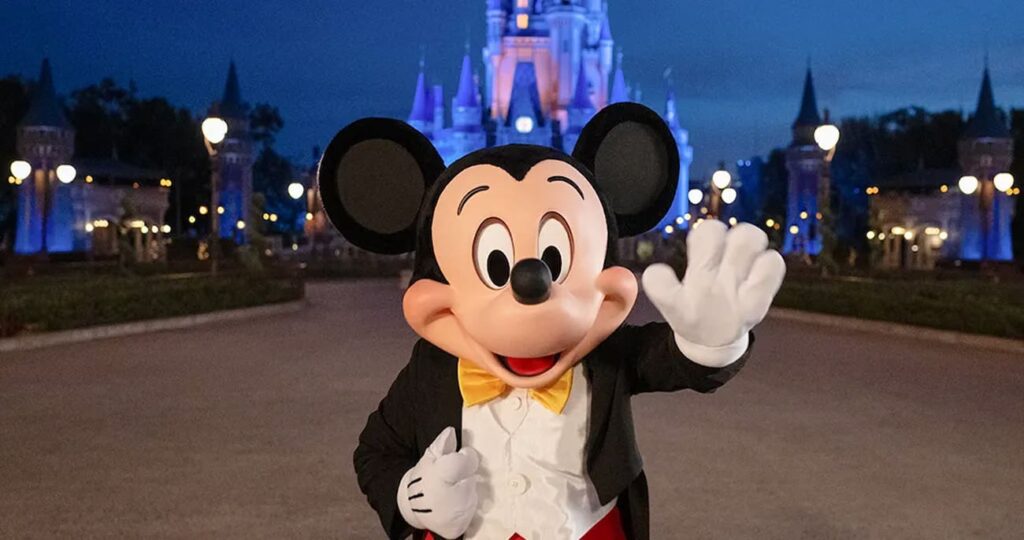 Mickey acena em frente ao Castelo da Cinderela no Magic Kingdom Park, parque temático de Walt Disney World Resort em Orlando