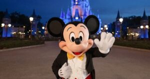 Mickey acena em frente ao Castelo da Cinderela no Magic Kingdom Park, parque temático de Walt Disney World Resort em Orlando