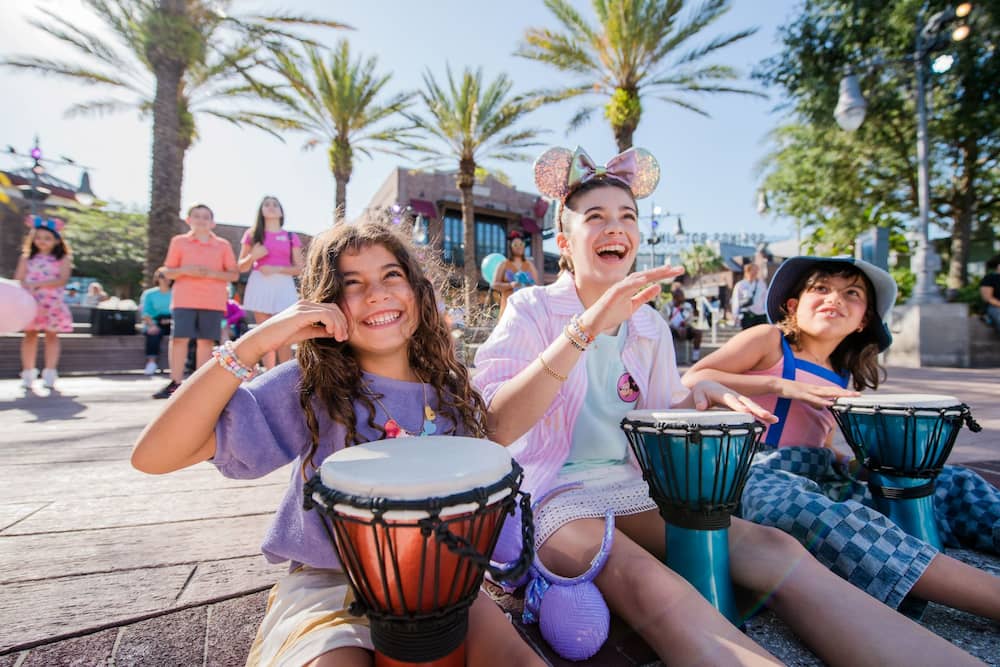 Crianças brincam e se divertem tocando tambores durante o dia em Disney Springs