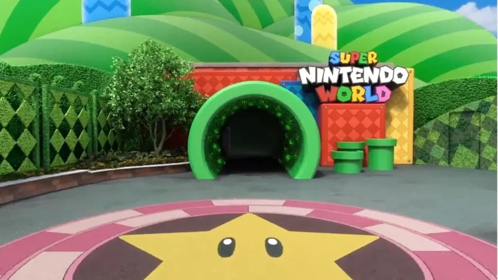 Foto da Entrada imersiva da área Super Nintendo World da Universal Studios. Mostra o cano que é um tunel para a entrada principal, as montanhas do jogo e as letras típicas do Super Mario World. No chão tem o desenho da estrela que dava o poder de invincibilidade