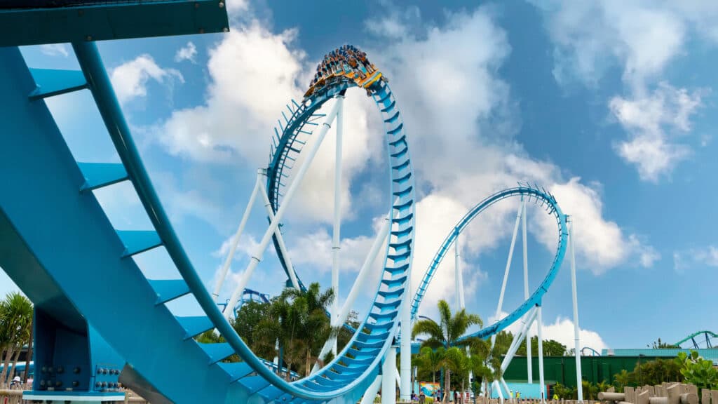 Imagem da nova atração do parque temático SeaWorld Orlando, que mostra os visitantes em pé no carrinho descendo pelos trilhos da montanha russa que causa sensação de surf