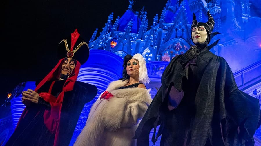 Foto dos vilões Jafar, Cruela de Vil e Malévola em frente ao casteloda Cinderela no parque de diversões Magic Kingdom em Walt Disney World resort, durante a festa de Halloween Mickey's Not So Scary Halloween Party, posando com cara de maus