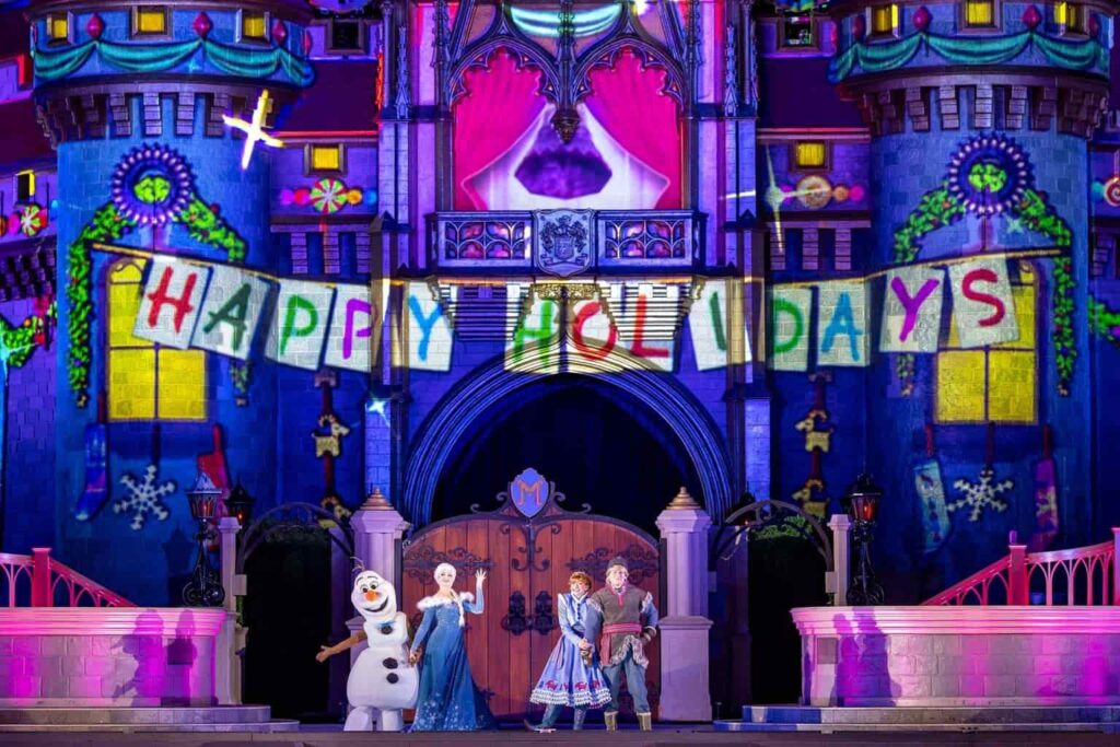 Foto do Castelo da Cinderela no Magic Kingdom, com iluminação especial do show que conta com a presença do Olaf, Anna, Elsa e Kristoff durante a festa de natal Mickey's Very Merry Christmas Party