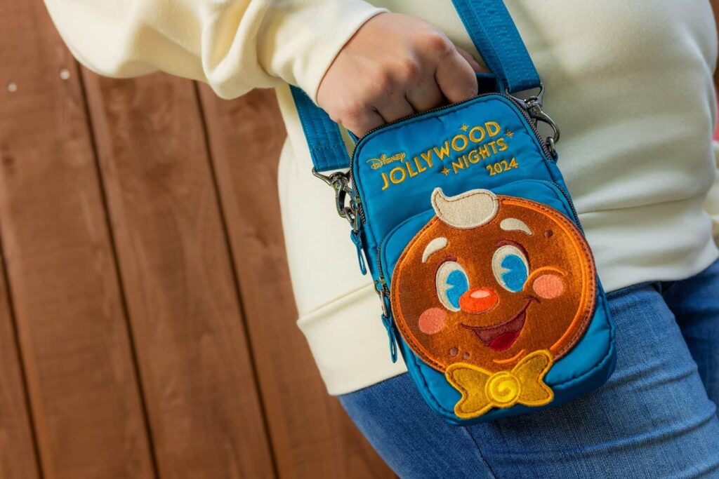 foto da bolsa lug, que foi feita exclusivamente para as festas de natal da Disney. a bolsa é transversal azul e conta com um boneco em formato de biscoito de natal