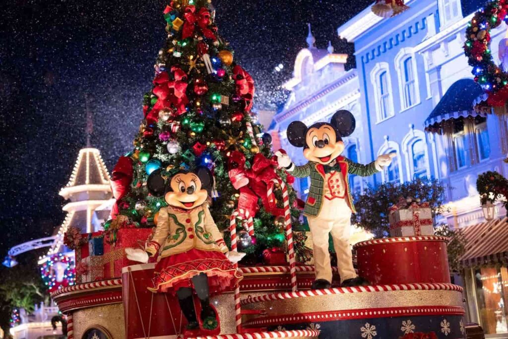 Mickey e Minnie em um carro alegórico do desfile da festa de Natal: Mickey's Very Merry Christmas Party, junto a uma árvore de natal e usando roupas temáticas da época, passando pela main street, no parque Magic Kingdom em Orlando