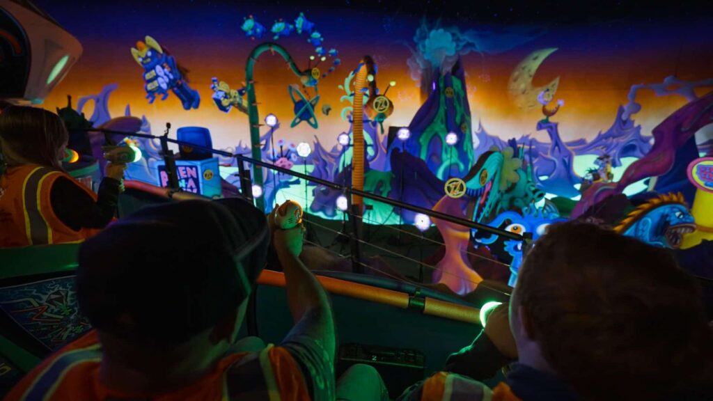 foto mostra pessoas nos carrinhos da atração do Magic Kingdom, Buzz Lightyear Ranger Spin, atirando nos alvos enquanto se divertem no mais famoso parque de diversões de Walt Disney World Resort