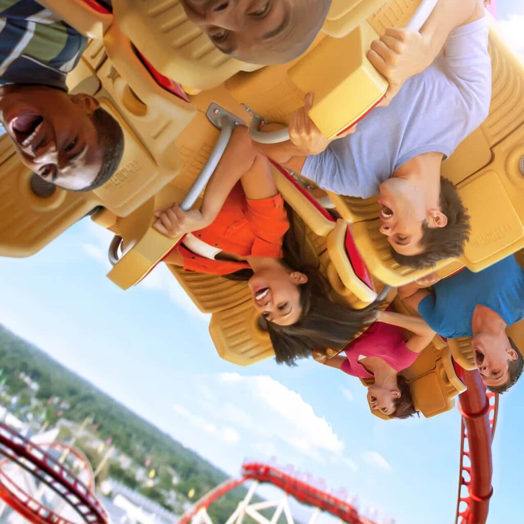 pessoas gritam emocionadas e se divertem durante looping da atração hollywood rip ride rockit, montanha russa radical do parque universal studios orlando