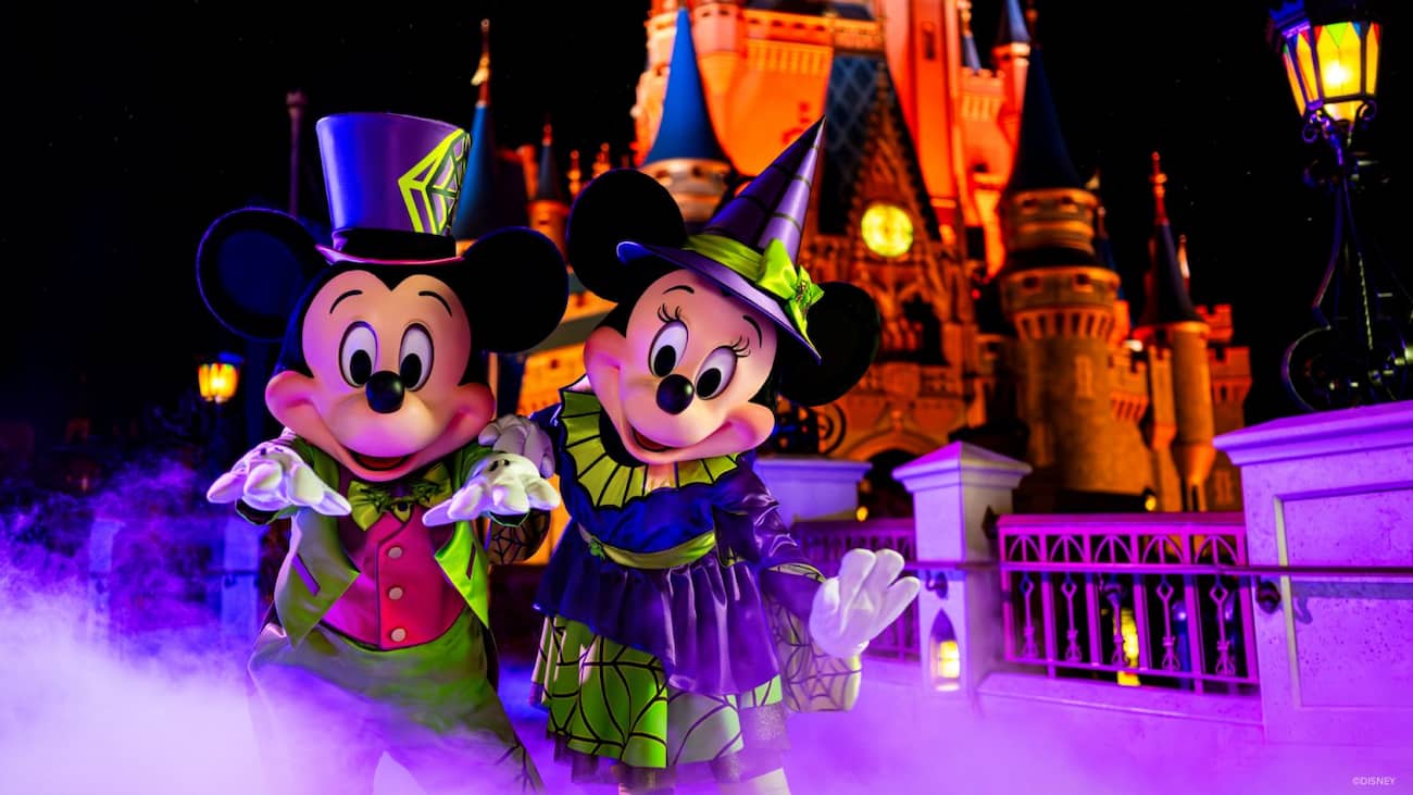 Mickey e Minnie Mouse com suas fantasias típicas de Halloween, em frente ao Castelo da Cinderela, no parque Magic Kingdom