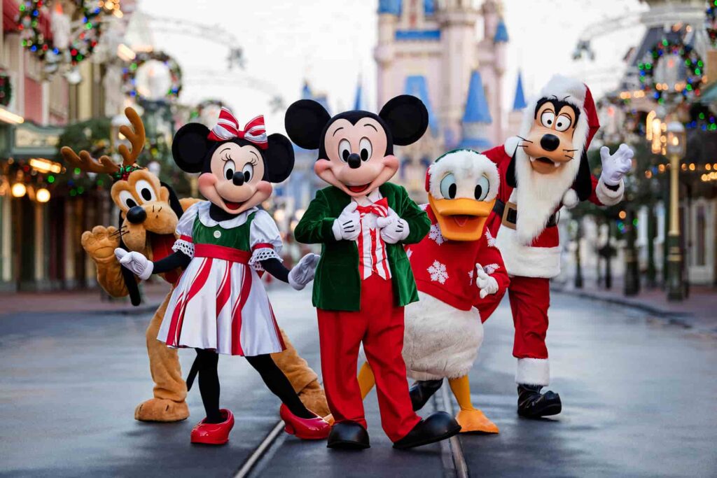 Mickey Mouse, Minnie Mouse, Pato Donald, Pluto e Pateta, vestidos com roupas natalinas no meio da Main Street USA, rua principal do parque temático Magic Kingdom, em Walt Disney World Resort, na Florida