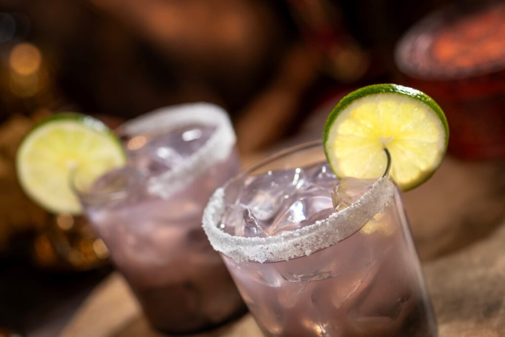 dois copos com bebida levemente lilás com uma rodela de limão no copo, a bebida é a margarita do pub pirata Beak and Barrel do Magic Kingdom na Disney