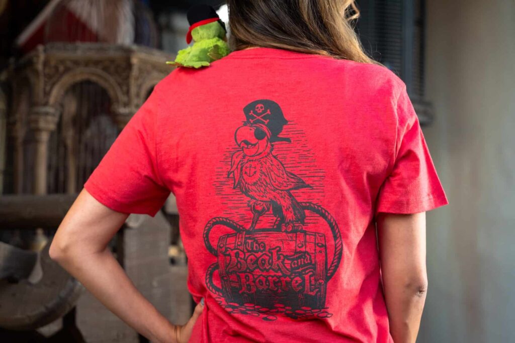 parte das costas da camiseta temática que celebra a inauguração do novo bar pirata da Disney, o Beak and Barrel no Magic Kingdom em frente a atração dos Piratas do Caribe