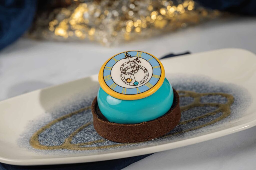 sobremesa inspirada na Cinderela, com um chocolate em formato e com desenho de um relógio marcando meia noite
