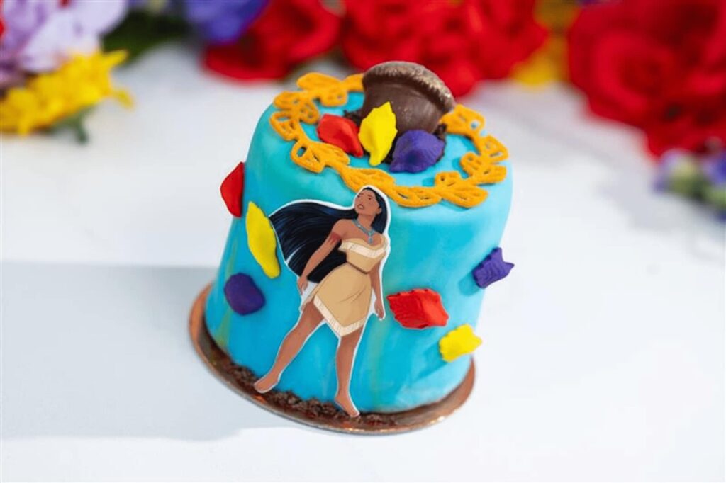 bolo da Pocahontas, na cor azul e com várias folhas da música cores do vento