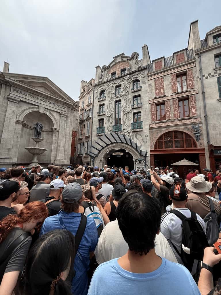 Entrada da atração Harry Potter and Battle of Ministry, completamente cheia de pessoas, abarrotada e disputadíssima na área de Animais Fantásticos e onde Habitam