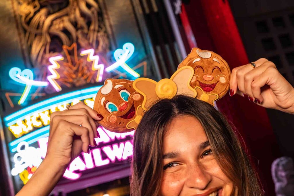Mulher exibe suas orelhinhas da Minnie temáticas da festa natalina Jollywood Nights, em frente ao teatro chinês e da atração Mickey e Minnie Runaway Railway no parque temático Hollywood Studios na Disney