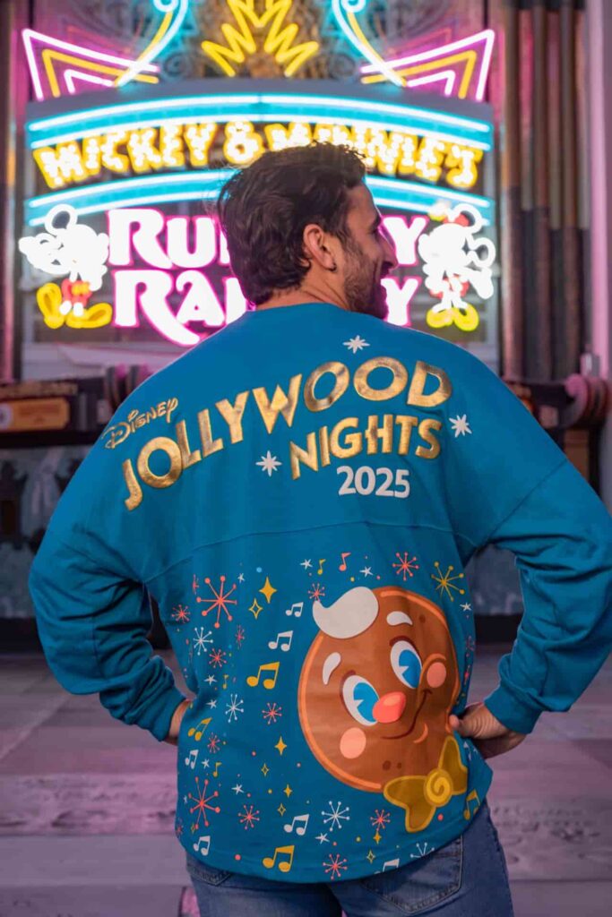 Homem em frente ao teatro chinês, na atração Mickey e Minnie Runaway Railway, exibe a Spirit Jersey da festa Jollywood Nights, a festa de Natal do parque temático Hollywood Studios na Disney