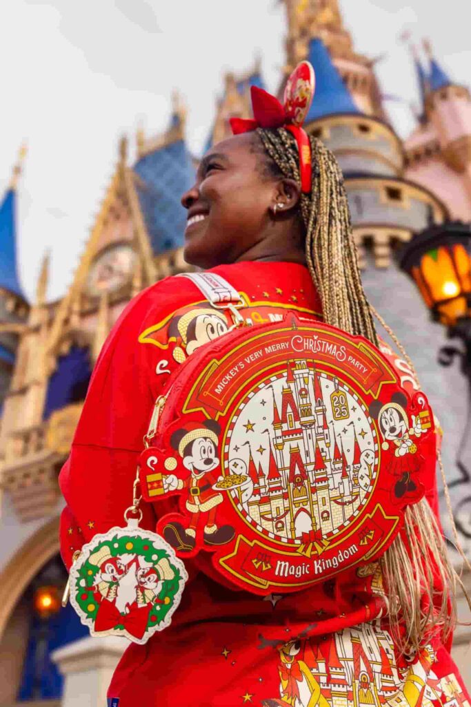 Mulher posa de costas para mostrar sua mochila Loungefly temática da festa de Natal do Magic Kingdom na Disney, a Mickey's Very Merry Christmas Party