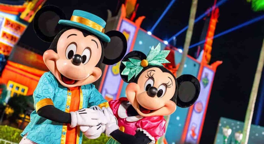 Mickey e Minnie de mãos dadas, podam em frente ao teatro chinês do Disney's Hollywood Studios, parque temático onde acontece a festa de natal Jollywood Nights que é um celebração bem glamurosa