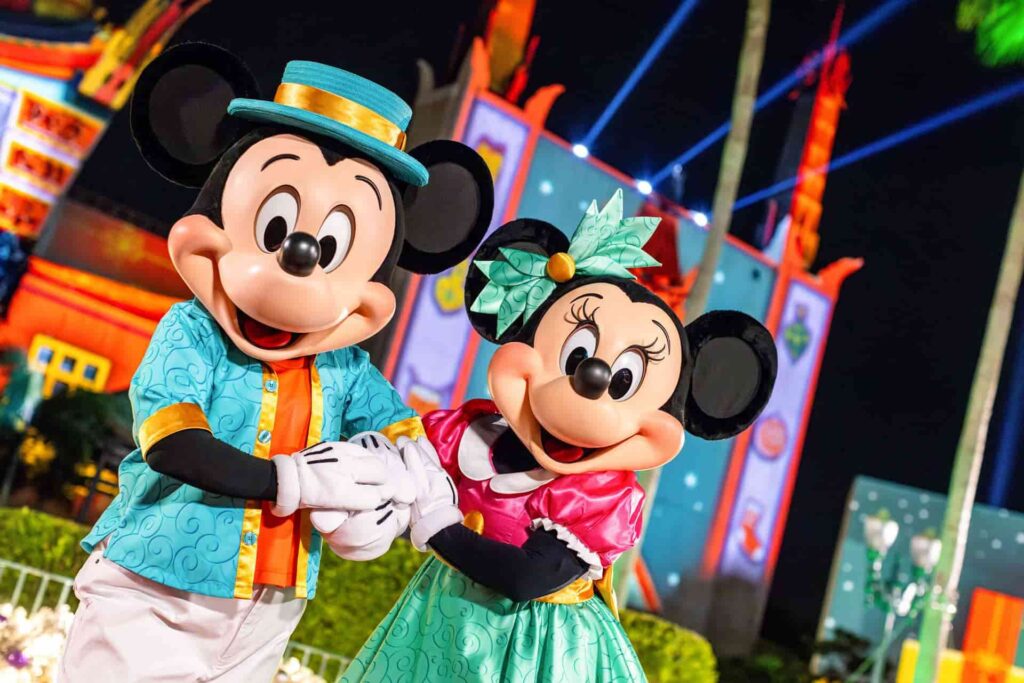 Mickey e Minnie de mãos dadas, podam em frente ao teatro chinês do Disney's Hollywood Studios, parque temático onde acontece a festa de natal Jollywood Nights que é um celebração bem glamurosa
