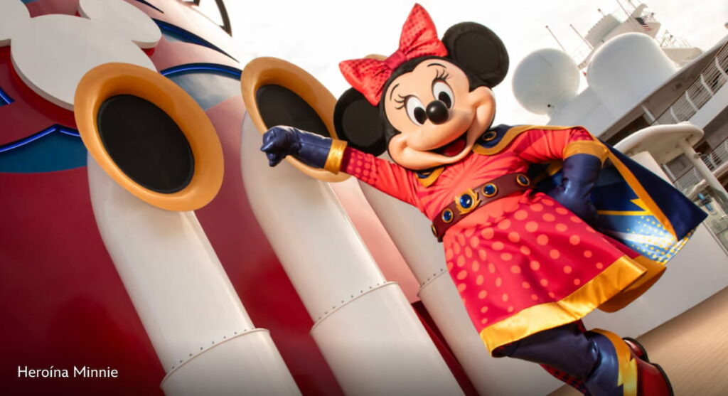 Minnie Mouse vestida de super heroina posa em frente ao navio Disney Destiny do Disney Cruise Line