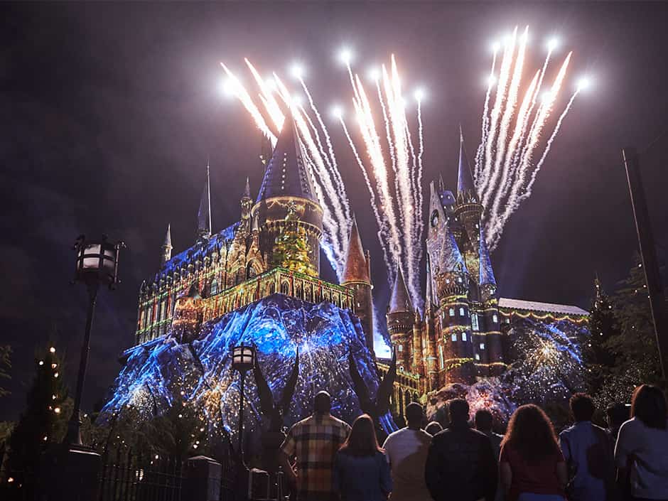 Castelo de Hogwarts no parque Islands of Adventure em Orlando no Universal Studios Resort, durante a noite com iluminações especial e fogos de celebração natalina