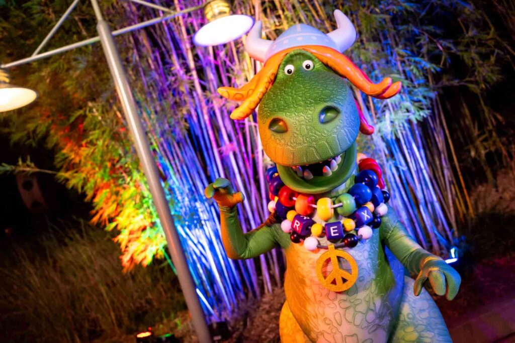 Rex de Toy Story com sua roupa de Partysaurus Rex em frente ao teatro chinês na glamurosa festa natalina Jollywood Nights que acontece anualmente no parque Hollywood Studios em Walt Disney World