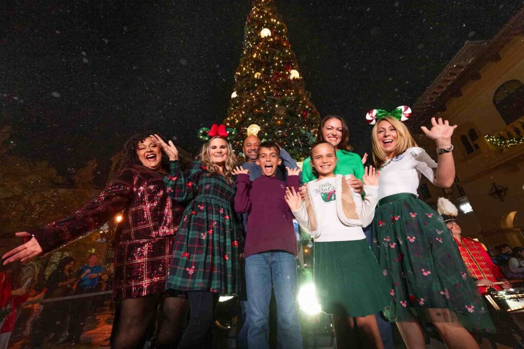 Família posa feliz em frente a grande árvore natal durante as festas de final de ano no Disney Springs
