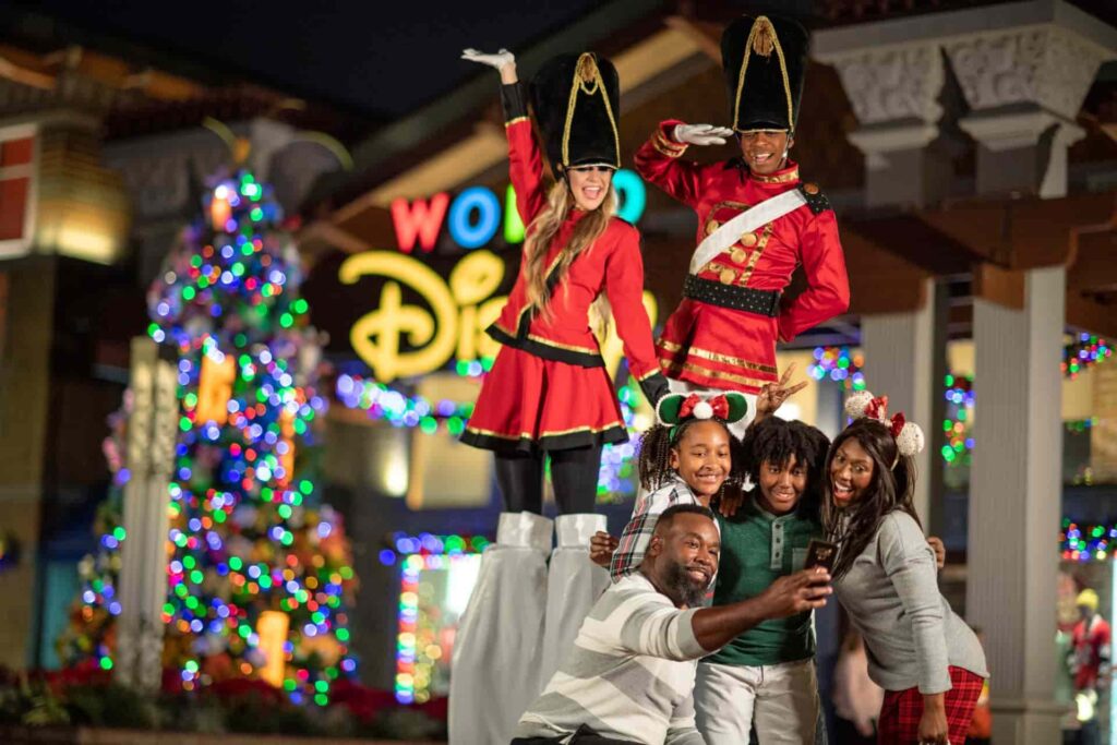 família posa feliz para foto junto as soldadinhas de chumbo que andam sobre pernas de pau durante as festas de final de ano no Disney Springs