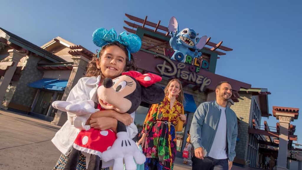 Família feliz em frente a uma das entradas (a que tem o Stitch que cospe água nas pessoas) da loja World of Disney, a maior loja da Disney no mundo, localizada em Disney Springs no Walt Disney World Resort