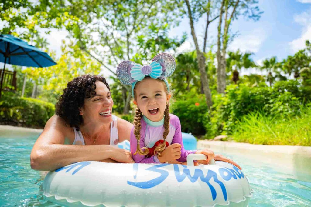 Menina com orelinhas da Minnie se diverte em boia no parque aquático da Disney, Blizzard Beach, com sua mãe