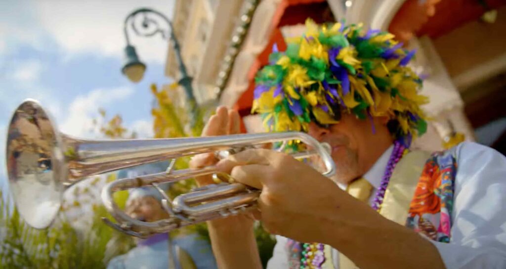 homem fantasiado toca instrumento musical durante o evento Mardi Gras da Universal Orlando