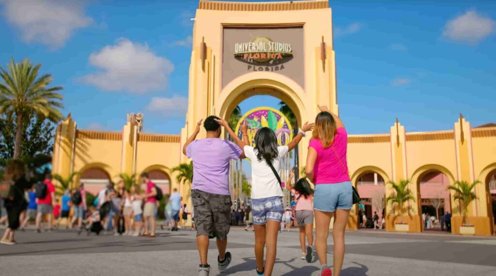Familia chega animada para entrar no parque temático Universal Studios Florida durante o evento Mardi Gras