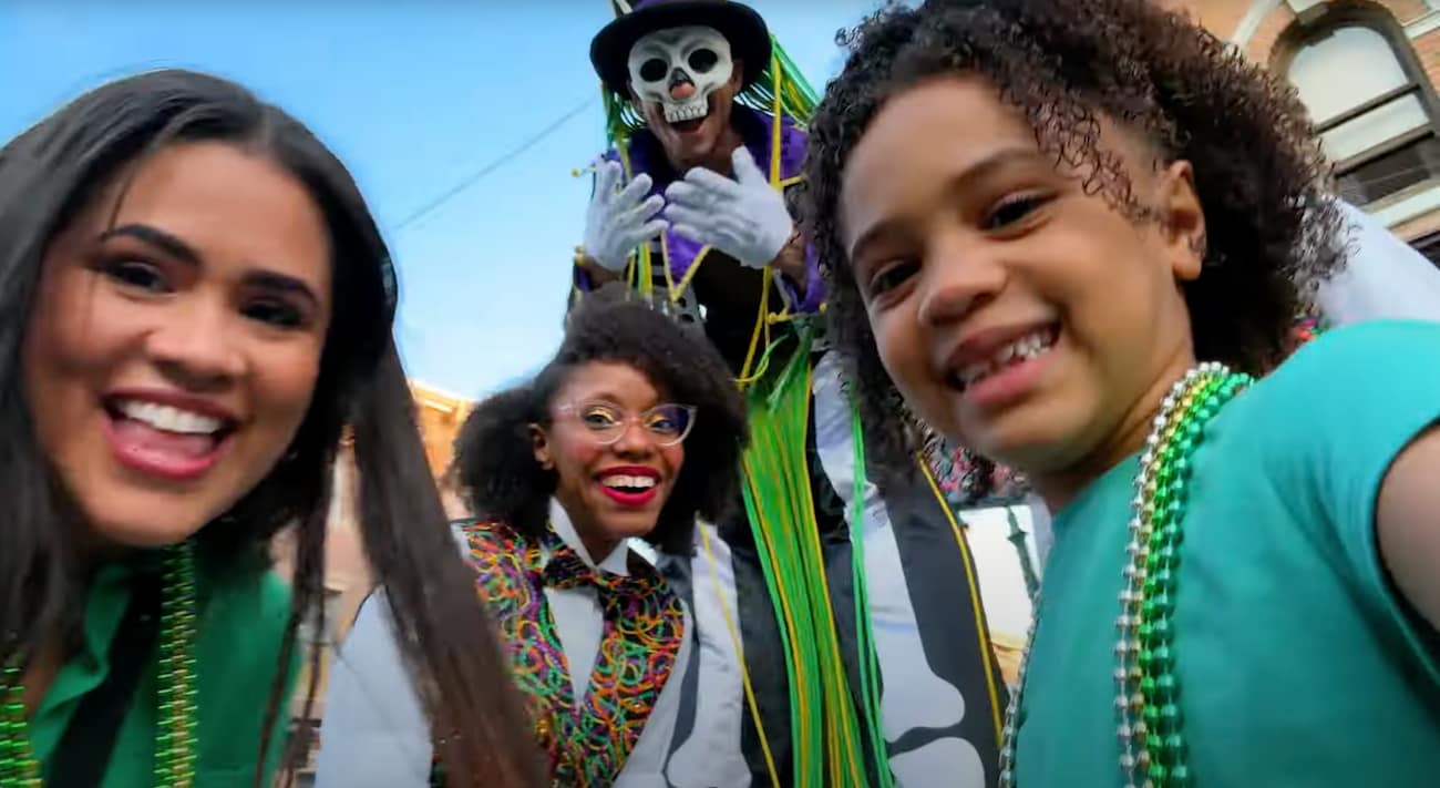 Familia posa sorrindo com um dos artistas do Mardi Gras, evento de Carnaval da Universal Studios em Orlando