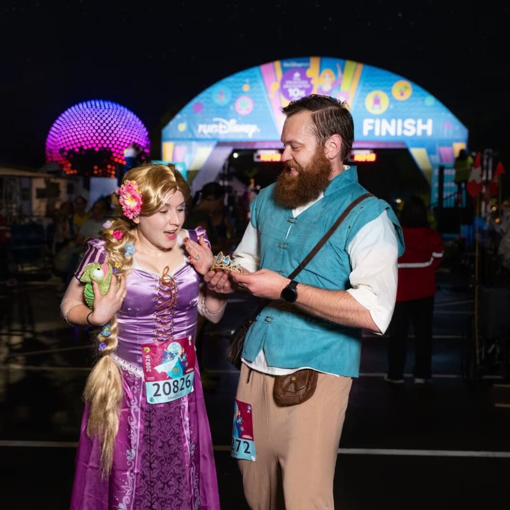 Casal fantasiado de Rapunzel e Flynn Rider posam para foto após terminar a corrida da RunDisney em Orlando dentro do Walt Disney World Resort