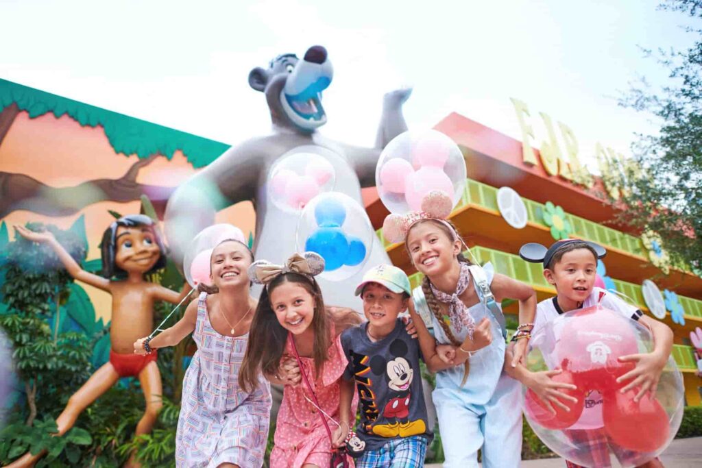 Crianças super felizes e animadas em frete ao Baloo com balões em formato de Mickey, brincam no hotel Disney's Pop Century Resort em Orlando