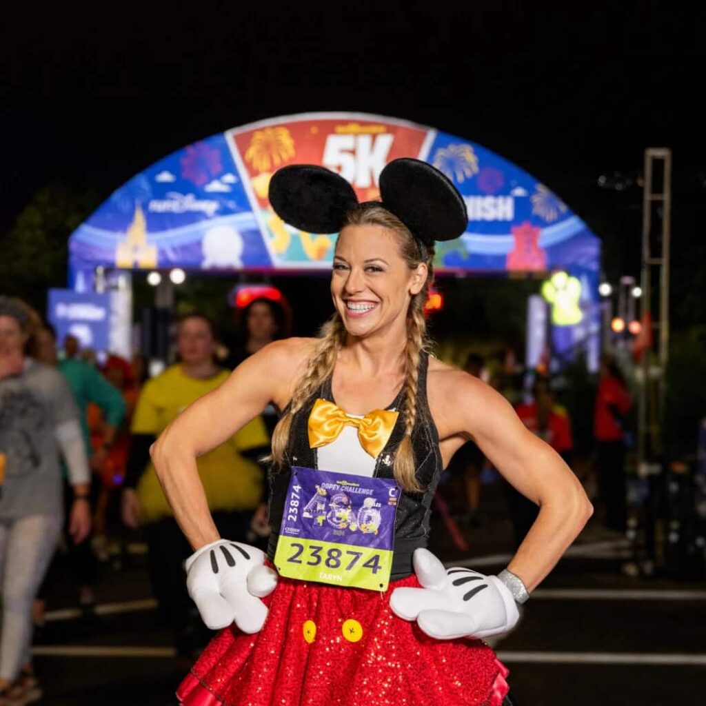Mulher fantasiadas de Mickey feliz ao completar a corrida da RunDisney de 5k em Walt Disney World Resort