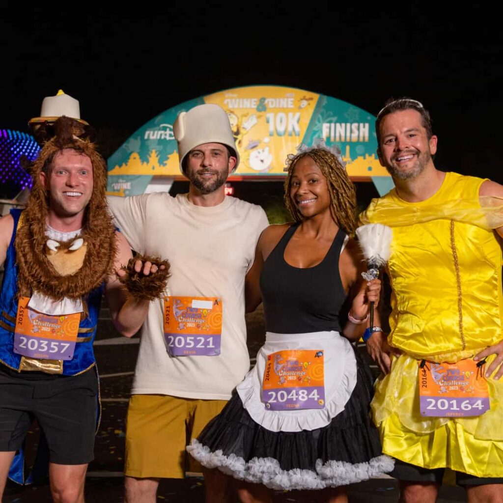 Grupo de amigos com fantasias temáticas de A Bela e a Fera posam para foto após terminar a corrida da Meia Maratona da RunDisney em Orlando dentro do Walt Disney World Resort