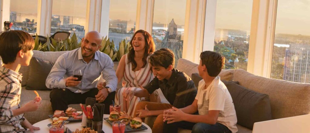 Pessoas riem e se divertem ao por do sol no rooftop Bar Bistro 17 no hotel da Universal Aventura