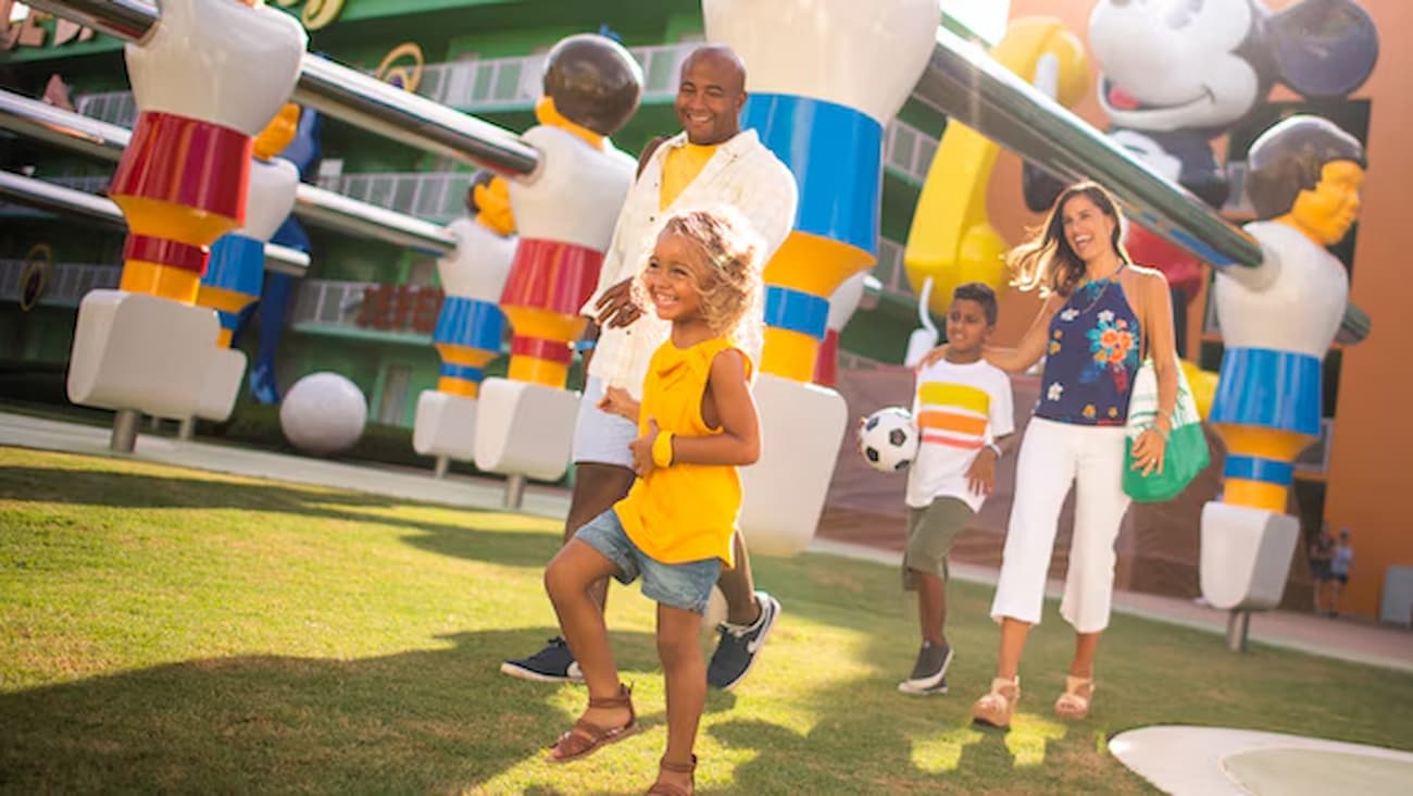 Familia anda feliz e saltitante pelo hotel da Disney, Disney's Pop Century Resort em Orlando como parte do Walt Disney World Resort, um dos hotéis econômicos do complexo que contempla o Skyliner, o teleférico da Disney