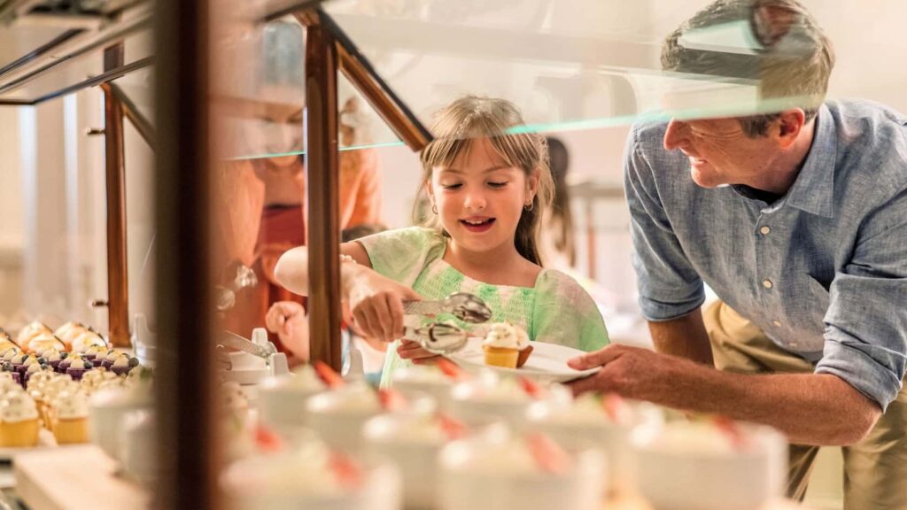 Pai e filha se servem no buffet no restaurante 1900 Park Fare no Disney's Grand Floridian Resort em Walt Disney World Resort