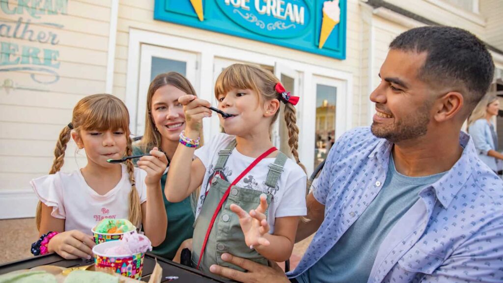 Crianças e seus pais comem sorvete em Disney's Boardwalk
