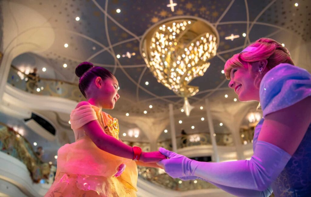 Cinderela se encontra com menininha fantasiada de Bela no navio Disney Wish
