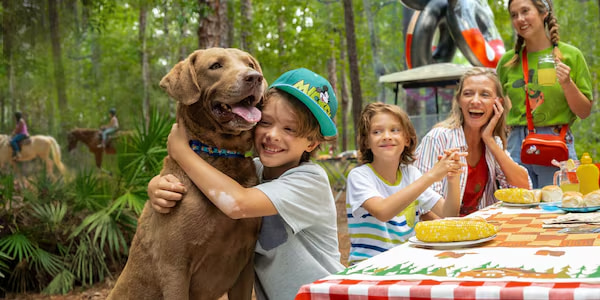 Família se diverte com seu cachorro em mesa no Fort Wilderness Resort, hotel do complexo de Walt Disney World Resort