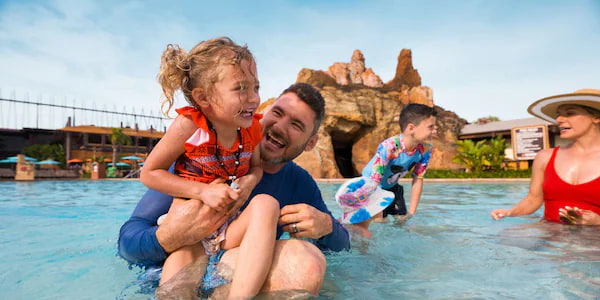 Crianças se divertem com seus pais na piscina do Disney's Polynesian Resort, hotel de luxo da Disney