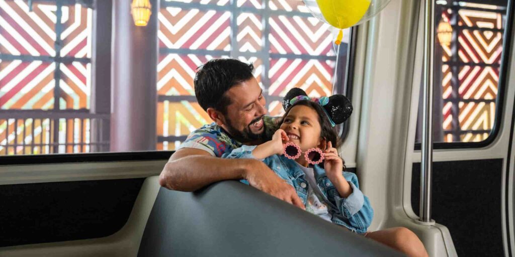 Menina olha sorrindo para seu pai dentro do monorail em Walt Disney World Resort
